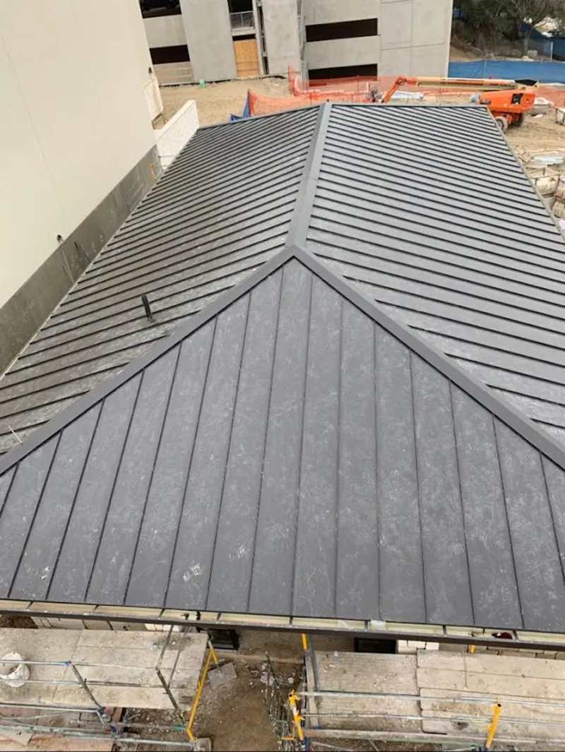 Commercial metal roof construction with crane equipment in Canton